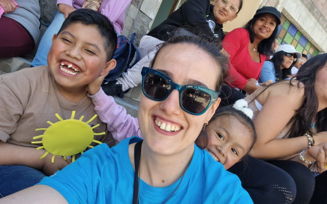 Voluntaria de My Mission sonriendo con niños durante la misión en Quito.